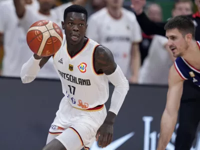 Germany guard Dennis Schroder (17) dribbles near Serbia guard Vanja Marinkovic during the championship game of the Basketball World Cup in Manila, Philippines, Sunday, Sept. 10, 2023. (AP Photo/Michael Conroy)
