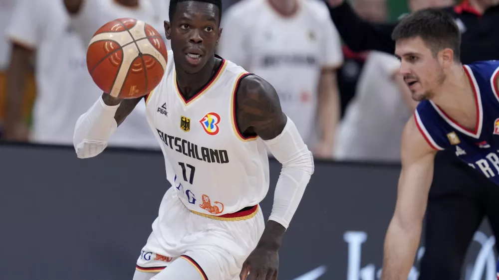 Germany guard Dennis Schroder (17) dribbles near Serbia guard Vanja Marinkovic during the championship game of the Basketball World Cup in Manila, Philippines, Sunday, Sept. 10, 2023. (AP Photo/Michael Conroy)
