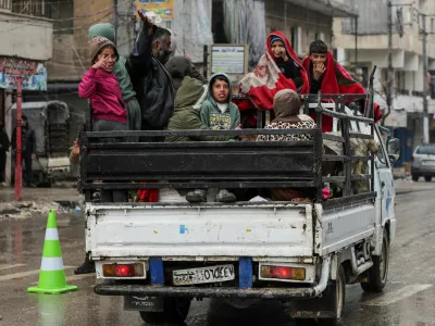 People ride in the back of a vehicle in the Ashrafieh neighbourhood, after the Kurdish-led Syrian Democratic Forces (SDF) fighters left the Syrian city of Aleppo on Sunday, according to Ekhbariya TV, following a ceasefire deal that allowed evacuations after days of deadly clashes, in Aleppo, Syria, January 11, 2026. REUTERS/Khalil Ashawi