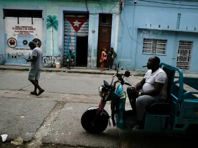 FILE PHOTO: Errilddy Almeida sits on his cargo motorbike during a blackout as top officials of the National Assembly announce that the Cuban economy is predicted to grow 1% in 2026, in Havana, Cuba December 18, 2025. REUTERS/Norlys Perez/File Photo