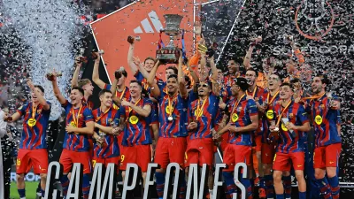 Soccer Football - Spanish Super Cup - Final - FC Barcelona v Real Madrid - King Abdullah Sports City Stadium, Jeddah, Saudi Arabia - January 12, 2026 FC Barcelona's Ronald Araujo lifts the trophy with teammates after winning the Spanish Super Cup final REUTERS/Stringer