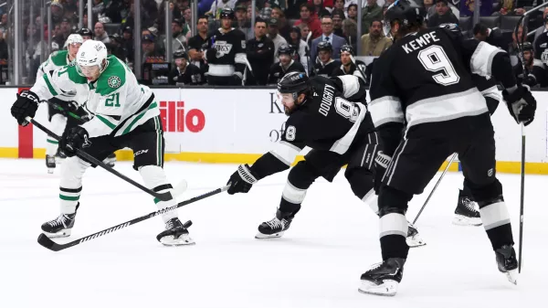 Dallas Stars left wing Jason Robertson (21) shoots against Los Angeles Kings defenseman Drew Doughty (8) as right wing Adrian Kempe (9) watches during the third period of an NHL hockey game, Monday, Jan. 12, 2026, in Los Angeles. (AP Photo/Jessie Alcheh)