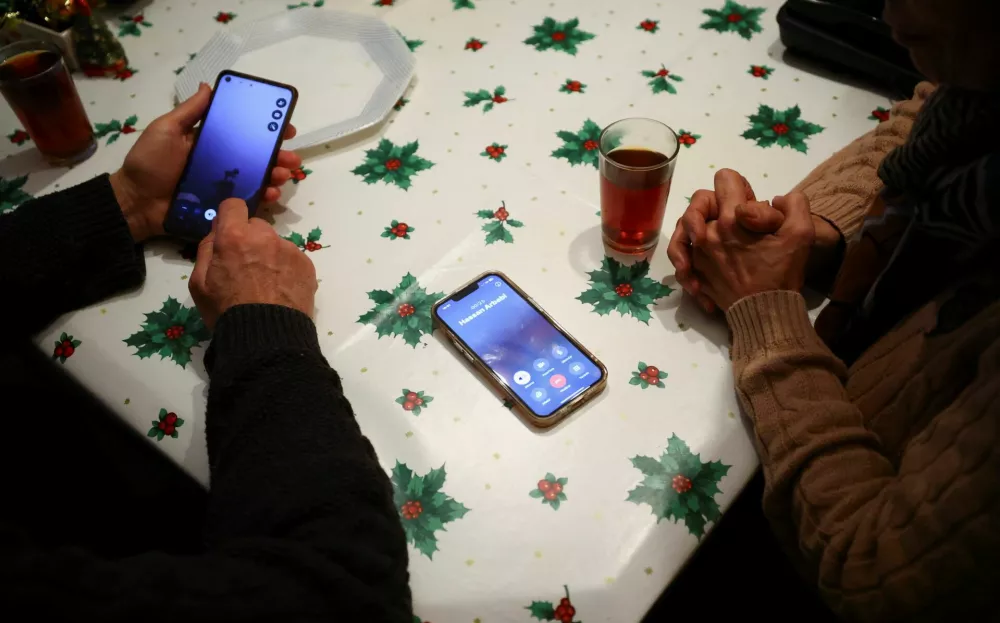 Said and Guiti, who have lived in Spain for over 40 years as refugees from Iran, try to call relatives in Iran from Barcelona, Spain January 13, 2026. REUTERS/ Albert Gea