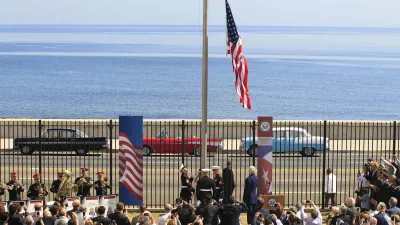 U.S. marines raise the U.S. flag while watched over by U.S. Secretary of State John Kerry (C, at lectern, back to camera) at the U.S. embassy in Havana, Cuba, August 14, 2015. U.S. Marines raised the American flag at the embassy in Cuba for the first time in 54 years on Friday, symbolically ushering in an era of renewed diplomatic relations between the two Cold War-era foes. REUTERS/Stringer    TPX IMAGES OF THE DAY