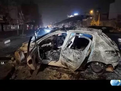 A burnt car lies on the road following unrest sparked by dire economic conditions, in a place given as Tehran, Iran, January 10, 2026, in this screengrab from Iran's state media broadcast footage. IRIB via WANA(West Asia News Agency) via REUTERS ATTENTION EDITORS - THIS PICTURE WAS PROVIDED BY A THIRD PARTY. IRAN OUT. NO COMMERCIAL OR EDITORIAL SALES IN IRAN NO USE BBC PERSIAN. NO USE VOA PERSIAN. NO USE MANOTO. NO USE IRAN INTERNATIONAL. NO USE RADIO FARDA. FOR REUTERS CUSTOMERS ONLY. TEXT OVERLAY FROM SOURCE.