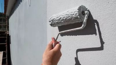 Painter's hand holding a roller filled with paint to paint an exterior wall / Foto: Leirao, Getty Images