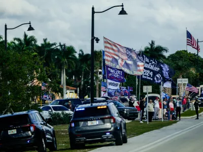 Supporters wave flags as President Donald Trump motorcades to his Mar-a-Lago club through Southern Boulevard, which the Town of Palm Beach Council recently voted to rename "President Donald J. Trump Boulevard," Friday, Jan. 16, 2026, in West Palm Beach, Fla. (AP Photo/Julia Demaree Nikhinson)