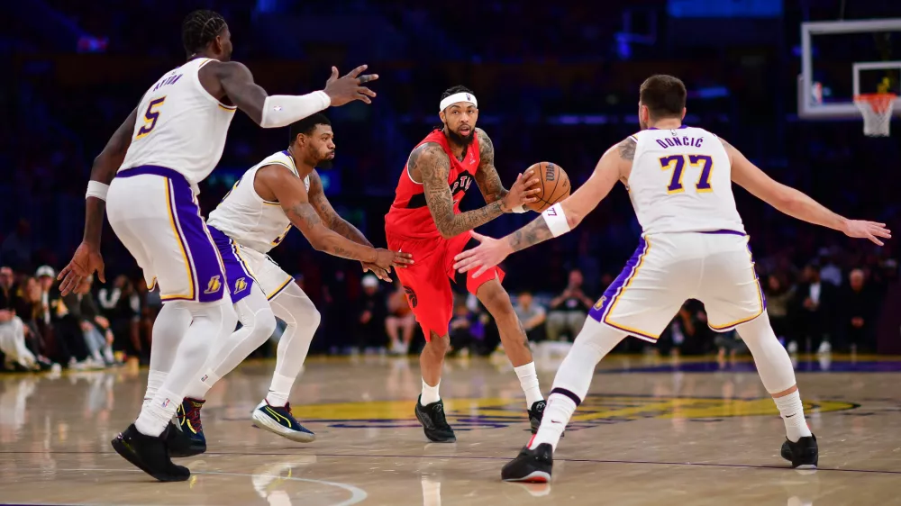 Jan 18, 2026; Los Angeles, California, USA; Toronto Raptors forward Brandon Ingram (3) moves the ball against Los Angeles Lakers center Deandre Ayton (5) guard Marcus Smart (36) and guard Luka Doncic (77) during the second half at Crypto.com Arena. Mandatory Credit: Gary A. Vasquez-Imagn Images
