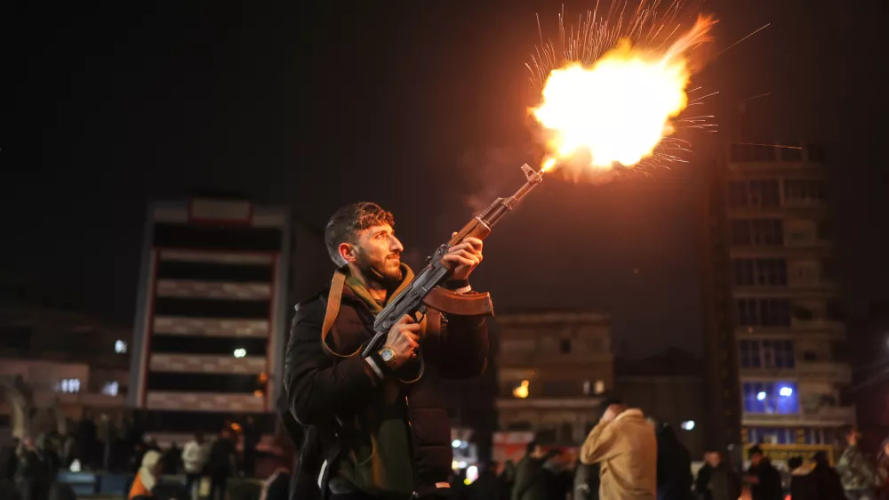 A member of the government forces fires into the air in celebration after taking control of the town from the Syrian Democratic Forces (SDF) in Raqqa, northeastern Syria, Sunday, Jan. 18, 2026. (AP Photo/Ghaith Alsayed)