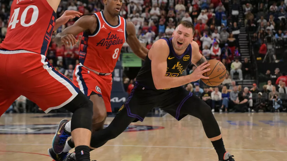 Jan 22, 2026; Inglewood, California, USA; Los Angeles Lakers guard Luka Doncic (77) is defended by Los Angeles Clippers center Ivica Zubac (40) and guard Kris Dunn (8) in the second half at Intuit Dome. Mandatory Credit: Jayne Kamin-Oncea-Imagn Images