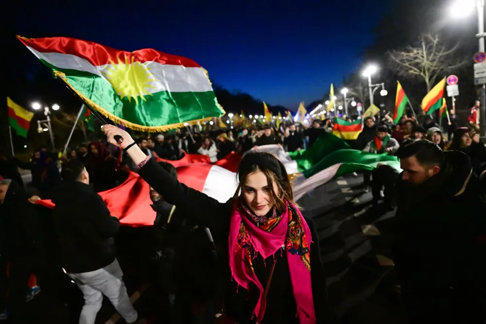 19 January 2026, Berlin: Protesters walk across 17 June Street during a demonstration with the slogan "No welcome for Islamist Ahmed al-Sharaa in Berlin" against the visit of the Syrian transitional president. The two-day visit planned for today has been postponed. Photo: Sebastian Christoph Gollnow/dpa