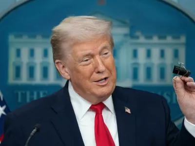 President Donald Trump holds a binder clip as he speaks during a press briefing at the White House in Washington, Tuesday, Jan. 20, 2026. (AP Photo/Mark Schiefelbein)