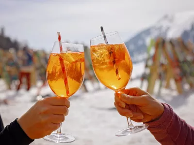 Happy family, enjoying ski holiday with children, sunny beautiful weather outdoors, people drinking Spritz on a sunny day