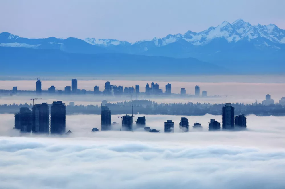 Building tops in Burnaby and Surrey rise above a thick layer of fog at dawn as a ridge of high pressure creates a coastal temperature inversion, as seen from Cypress Mountain in West Vancouver, British Columbia, Canada January 20, 2026. REUTERS/Chris Helgren   TPX IMAGES OF THE DAY