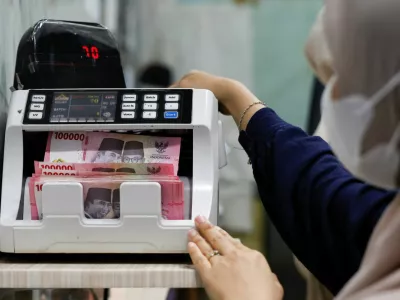 A teller counts rupiah bank notes at a money changer in Jakarta, Indonesia, January 20, 2026. REUTERS/Ajeng Dinar Ulfiana