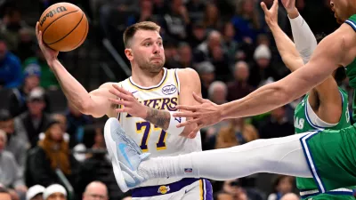 Jan 24, 2026; Dallas, Texas, USA; Los Angeles Lakers guard Luka Doncic (77) looks to pass the ball past Dallas Mavericks forward Dwight Powell (7) during the second half at the American Airlines Center. Mandatory Credit: Jerome Miron-Imagn Images