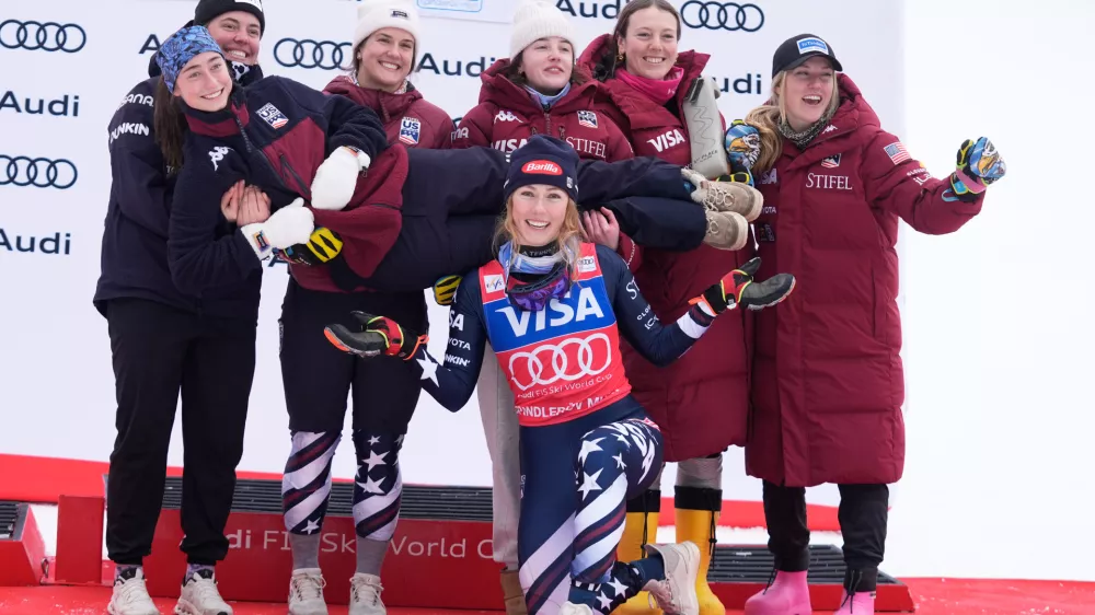 United States' Mikaela Shiffrin, center, foreground, poses with members of the women's US ski team after winning an alpine ski, women's World Cup slalom, in Spindleruv Mlyn, Czech Republic, Sunday, Jan. 25, 2026. (AP Photo/Giovanni Auletta)