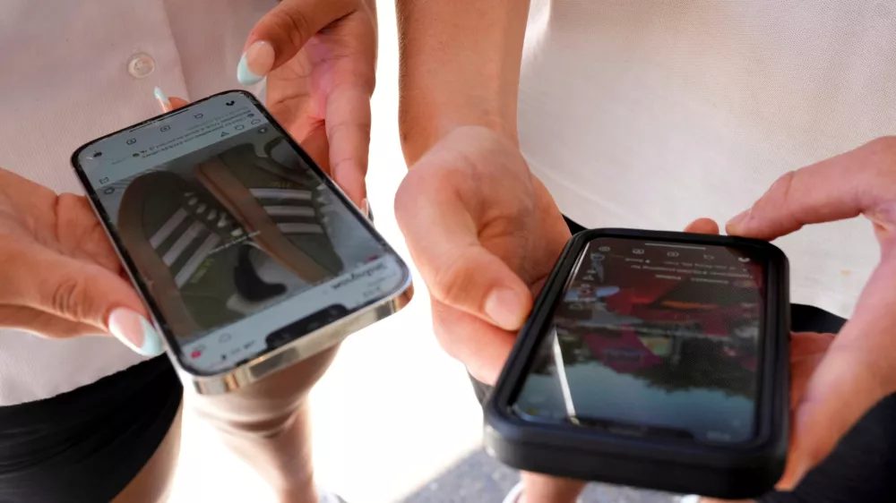 FILE - Young people use their phones to view social media in Sydney, Nov. 8, 2024. (AP Photo/Rick Rycroft, File)