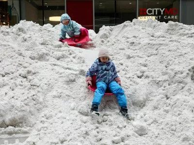 Children sled and play on a snow pile outside the New York Stock Exchange (NYSE), after a major winter storm spreads across a large swath of the United States, in New York City, U.S., January 26, 2026. REUTERS/Brendan McDermid / Foto: Brendan Mcdermid