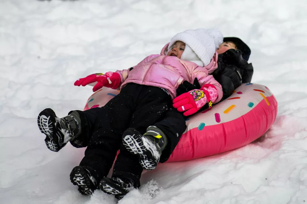 Children slide down a snow-covered hill, as a major winter storm spreads across a large swath of the United States, as it is seen from North Bergen, New Jersey, U.S., January 26, 2026. REUTERS/Eduardo Munoz / Foto: Eduardo Munoz