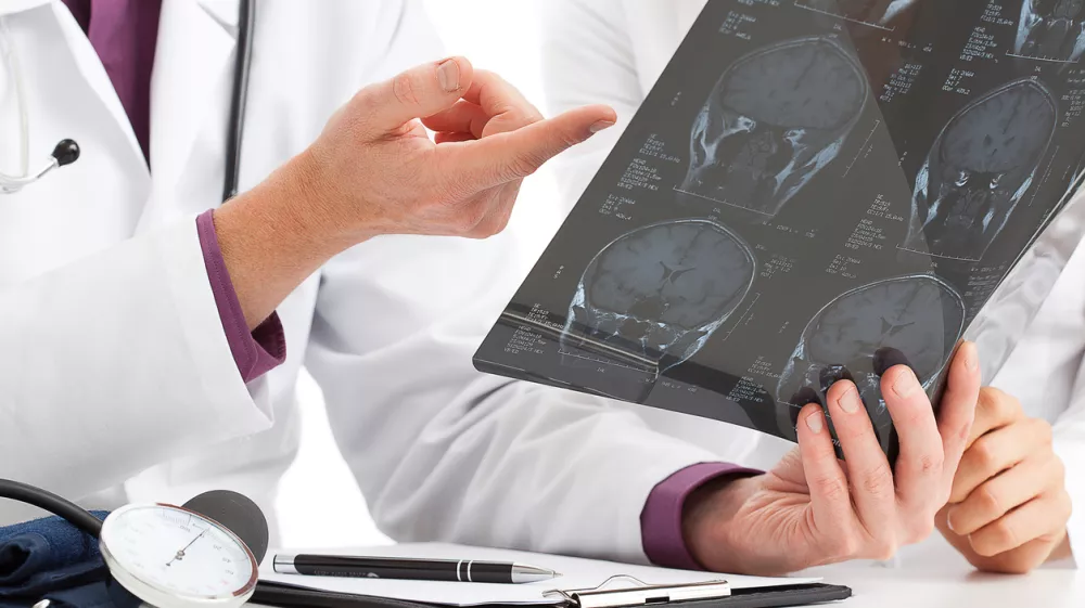 Physician looking at x-ray and debating about results