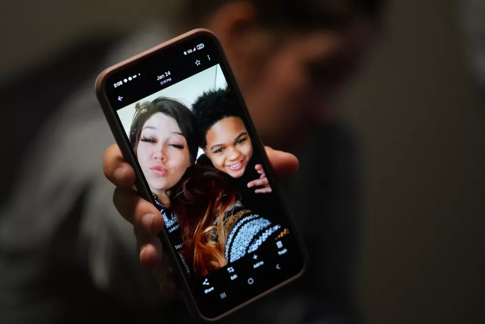 Cheyenne Hangaman shows a photograph of her and her son, EJ, 9, who along with his two brothers Kaleb, 8, and Howard, 6, drowned in a frozen pond Tuesday, Jan. 27, 2026, in Bonham, Texas. (AP Photo/Julio Cortez)