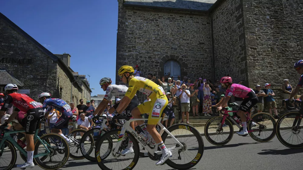 Ireland's Ben Healy, right in pink jersey, follows Slovenia's Tadej Pogacar, wearing the overall leader's yellow jersey, during the eighth stage of the Tour de France cycling race over 171.4 kilometers (106.5 miles) with start in Saint-Meen-le-Grand and finish in Laval Espace Mayenne, France, Saturday, July 12, 2025. (AP Photo/Thibault Camus)