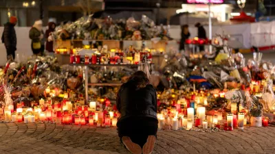 FILE PHOTO: A woman lights a candle at a makeshift memorial outside the "Le Constellation" bar, after a deadly fire and explosion during a New Year's Eve party, in the upscale ski resort of Crans-Montana in southwestern Switzerland, January 5, 2026. REUTERS/Umit Bektas/File Photo