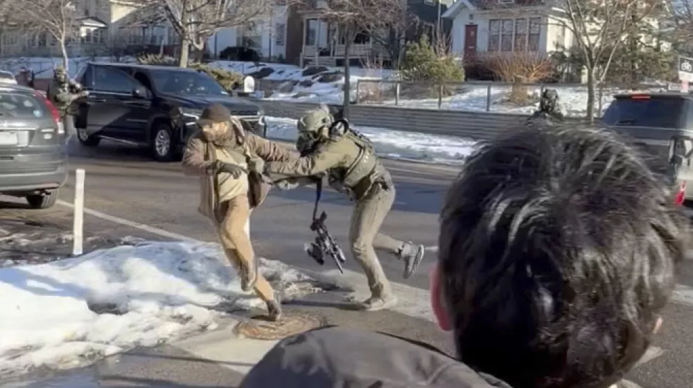 This image taken from video by Max Shapiro shows Alex Pretti, left, scuffling with federal immigration officers in Minneapolis on Jan. 13, 2026. (Max Shapiro via AP)