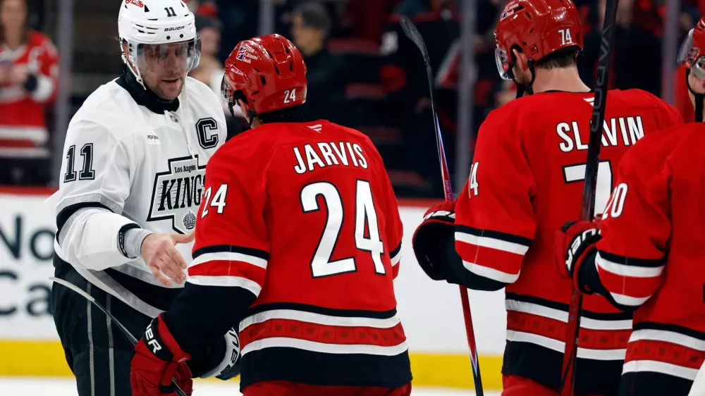 Los Angeles Kings' Anze Kopitar (11) shakes hands with Carolina Hurricanes' Seth Jarvis (24) after an NHL hockey game in Raleigh, N.C., Sunday, Feb. 1, 2026. (AP Photo/Karl DeBlaker)