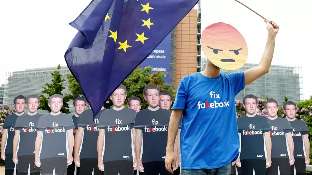 A protester holds an European Union flag next to cardboard cutouts depicting Facebook CEO Mark Zuckerberg during a demonstration ahead of a meeting between Zuckerberg and leaders of the European Parliament in Brussels, Belgium May 22, 2018. REUTERS/Francois Lenoir