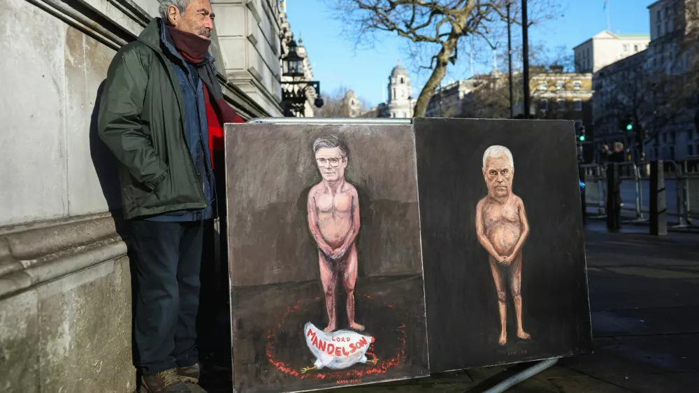 Artist Kaya Mar stands next to his satirical paintings depicting nude figures of British Prime Minister Keir Starmer and Andrew Mountbatten‑Windsor, the younger brother of Britain's King Charles, formerly Prince Andrew, Duke of York, as pressure builds on him to give evidence following the release of new U.S. Justice Department records linked to the late financier and convicted sex offender Jeffrey Epstein, titled "Mandy" and "Andy," on Downing Street in London, Britain, February 4, 2026. REUTERS/Toby Melville