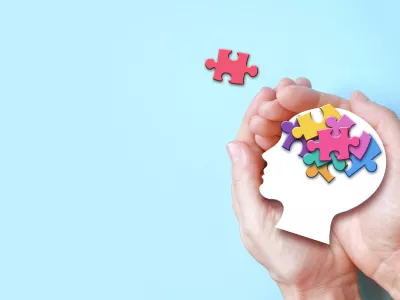 Hands holding paper head with jigsaw puzzle, Autism spectrum disorder family support concept, World Autism Awareness Day. / Foto: Belitas