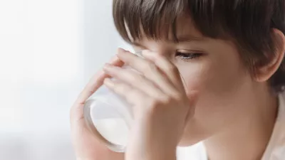 Cute boy drinking milk from glass at home on white background / Foto: Johnalexandr, Getty Images
