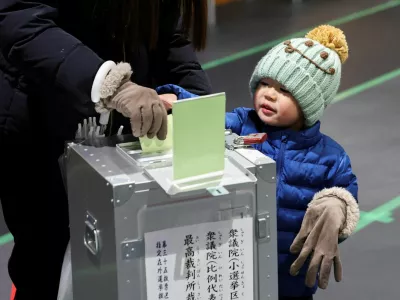 A boy looks on as his mother casts her ballot for a general election at a polling station in Tokyo, Japan, on February 8, 2026. REUTERS/Kim Kyung-Hoon