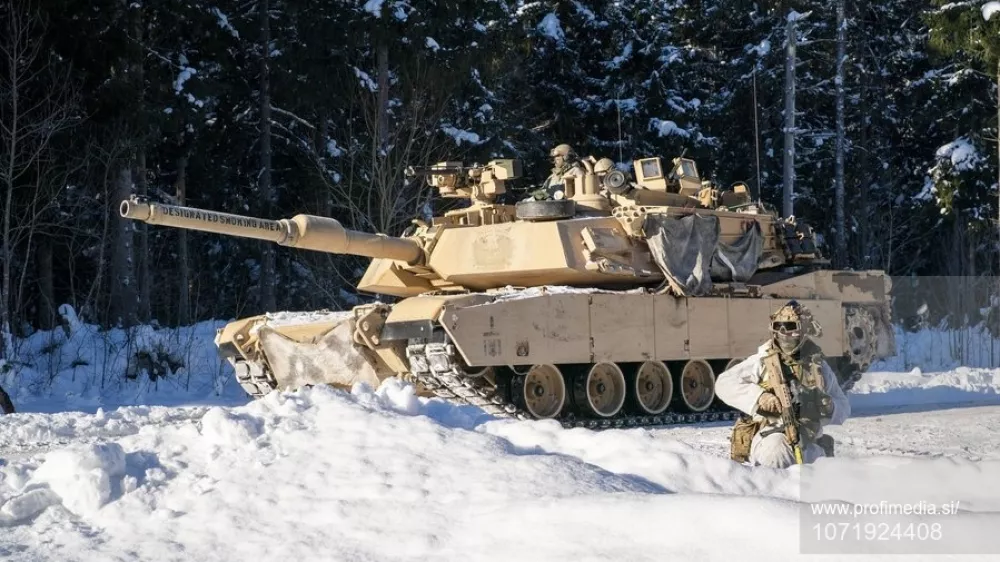 American Abrams tanks pass British soldiers from the 2nd Battalion The Royal Anglian Regiment (The Poachers) as they engage enemy troops on the Tapa range in Estonia where British soldiers are taking part in Exercise Winter Camp, which is part of Operation Cabrit, the UK's contribution to Nato's Forward Land Forces in Estonia and Poland. Picture date: Tuesday February 3, 2026.,Fotografija:1071924408, Licenca:Rights-managed, Omejitve:, Model izdaje:no