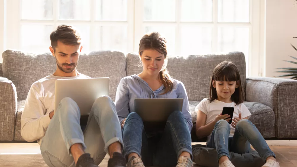 Family with kid sitting on floor at home using laptops and phone, parents and little child daughter consumers customers obsessed with devices gadgets, people internet technology addiction concept
