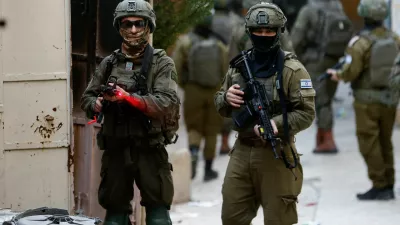 Israeli soldier points his weapon towards the camera, during a weekly settlers' tour in Hebron, in the Israeli-occupied West Bank, February 7, 2026. REUTERS/Mussa Qawasma