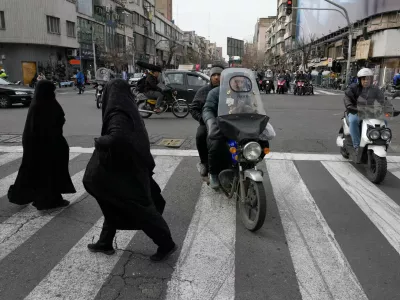 Women cross an intersection in downtown Tehran, Iran, Monday, Feb. 9, 2026. (AP Photo/Vahid Salemi)