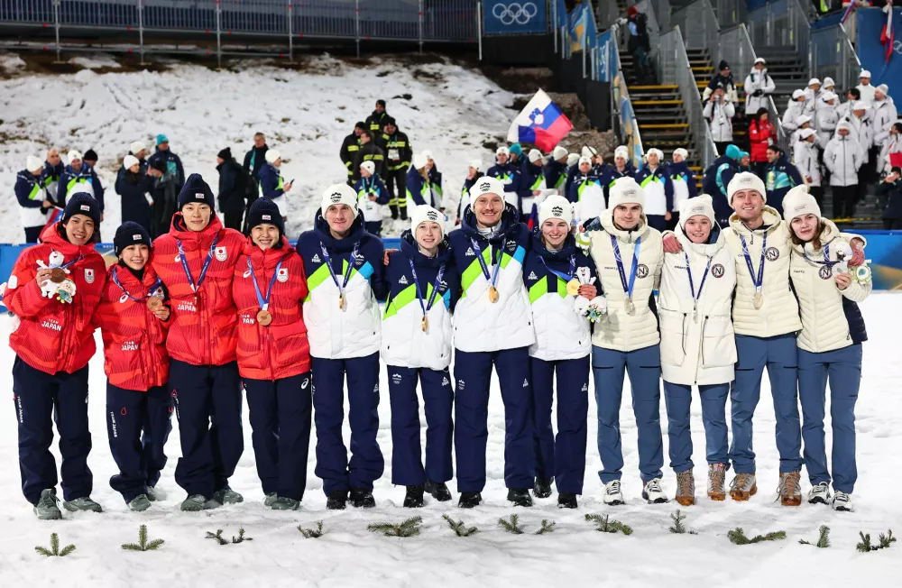 10 February 2026, Italy, Predazzo: (L-R) Norway's silver medallists Marius Lindvik, Eirin Maria Kvandal, Kristoffer Eriksen Sundal, and Anna Odine Strom, Slovenia's gold medallists Domen Prevc, Nika Prevc, Anze Lanisek, and Nika Vodan and Japan's bronze medallists Ren Nikaido, Sara Takanashi, Ryoyu Kobayashi, and Nozomi Maruyama celebrate after the Ski Jumping Mixed team competition of the 2026 Winter Olympic Games at Milan-Cortina. Photo: Daniel Karmann/dpa