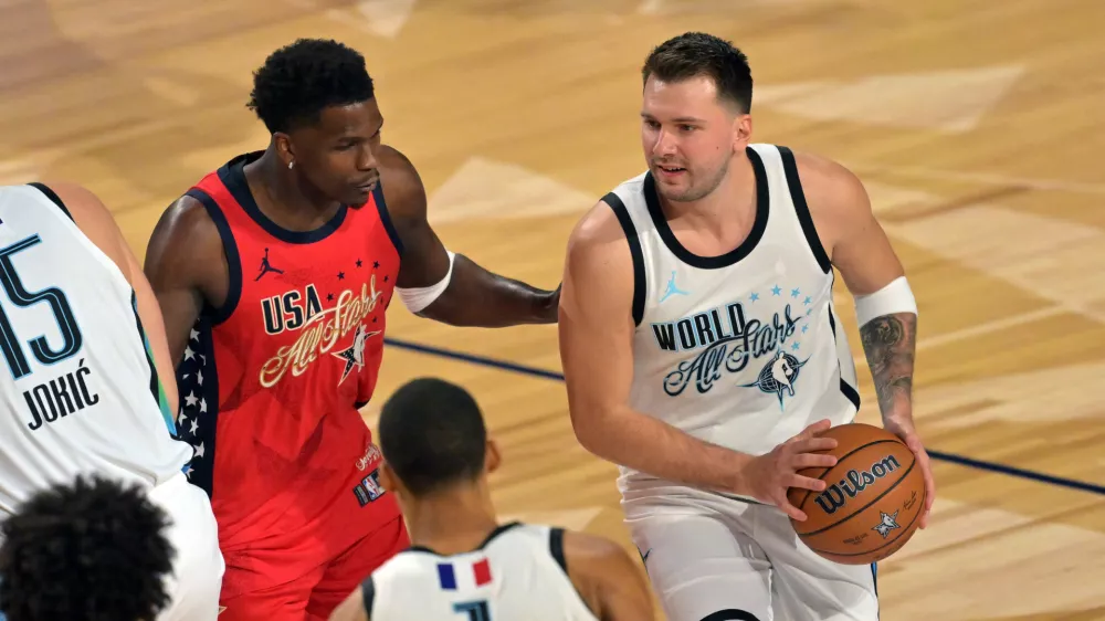 Feb 15, 2026; Inglewood, California, USA; Team World guard Luka Doncic (77) of the Los Angeles Lakers controls the ball against Team USA Stars guard Anthony Edwards (5) of the Minnesota Timberwolves in game one during the 75th NBA All Star Game at Intuit Dome. Mandatory Credit: Jayne Kamin-Oncea-Imagn Images