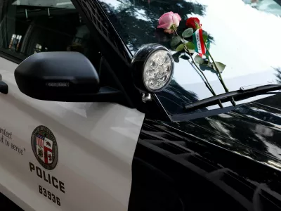 Flowers are placed on a police vehicle as people take part in a rally in support of Iranian protesters during a global day of action in Los Angeles, California, U.S., February 14, 2026.  REUTERS/Caroline Brehman