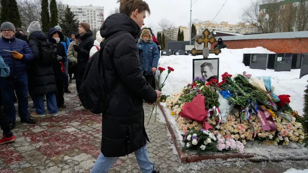 A man lays flowers at Russian opposition leader Alexei Navalny's grave, two years after his death, at the Borisovskoye Cemetery in Moscow, on Monday, Feb. 16, 2026. (AP Photo/Alexander Zemlianichenko)