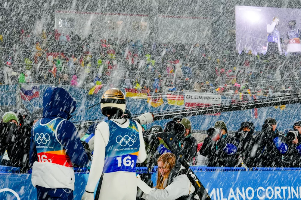 Anze Lanisek, left, and Domen Prevc, of Slovenia, look up at the video screen while a snowfall interrupts the final round jump of the ski jumping men's super team competition at the 2026 Winter Olympics, in Predazzo, Italy, Monday, Feb. 16, 2026. (AP Photo/Kirsty Wigglesworth)