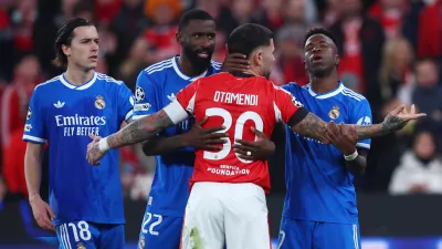 Soccer Football - UEFA Champions League - Play Off - First Leg - Benfica v Real Madrid - Estadio da Luz, Lisbon, Portugal - February 17, 2026 Real Madrid's Vinicius Junior, Alvaro Carreras and Antonio Rudiger clash with Benfica's Nicolas Otamendi REUTERS/Pedro Nunes