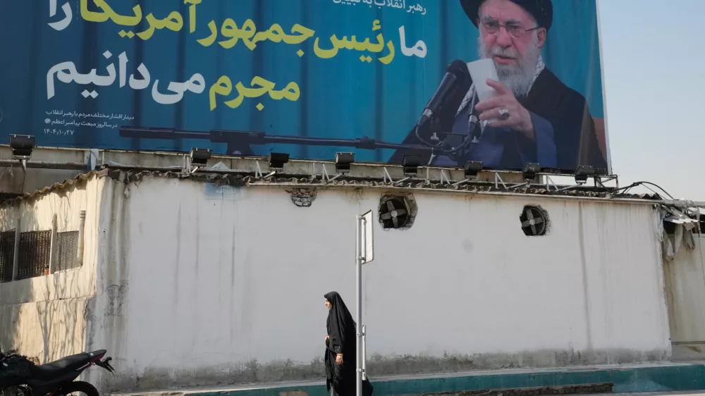 A woman walks past a billboard with an image of Iranian Supreme Leader Ayatollah Ali Khamenei with a quotation of him which says: "We recognise the President of America as a criminal," in Tehran, Iran, Tuesday, Feb. 17, 2026. (AP Photo/Vahid Salemi)