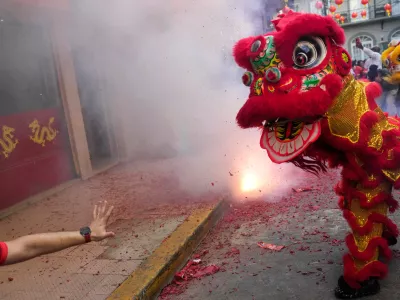 People perform a lion dance and throw fireworks to celebrate the Lunar New Year in Panama City, Tuesday, Feb. 17, 2026. (AP Photo/Matias Delacroix)