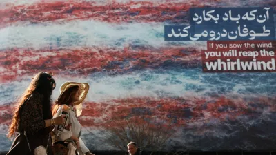 Iranian women walk past an anti-U.S. billboard in Tehran, Iran, February 19, 2026. Majid Asgaripour/WANA (West Asia News Agency) via REUTERS ATTENTION EDITORS - THIS PICTURE WAS PROVIDED BY A THIRD PARTY