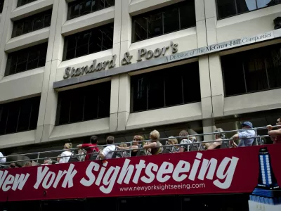 FILE - In this Aug. 6, 2011 photo, tourists drive past Standard & Poor's headquarters in New York's financial district Saturday, Aug. 6, 2011. (AP Photo/Karly Domb Sadof, File)