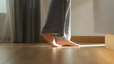 Barefoot woman on the wooden floor. Concept of the underfloor heating in the apartment.